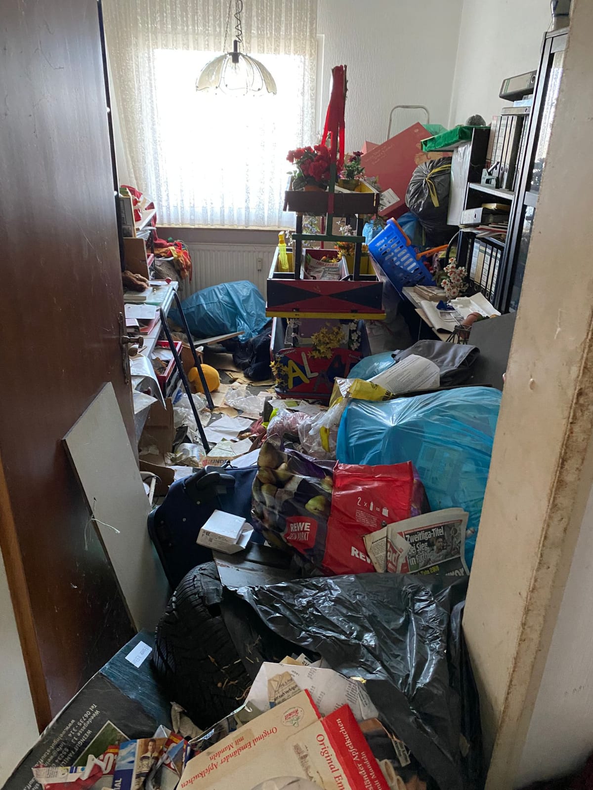 Entrümpelung in Köln Brück – teilweise geräumtes Zimmer mit befüllten blauen Abfallsäcken während der Beräumung